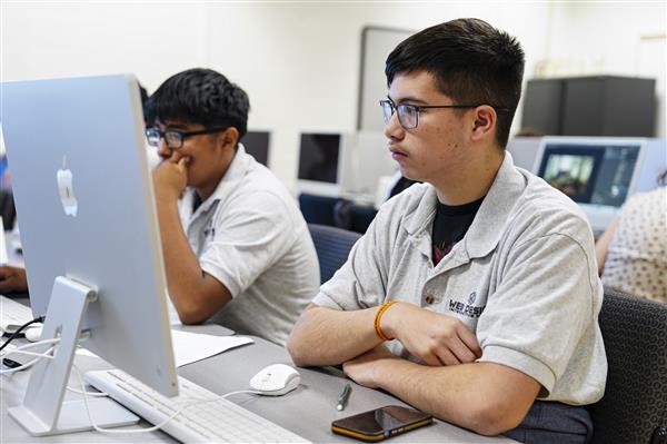 WEB DESIGN & INTERACTIVE MEDIA students working on computers